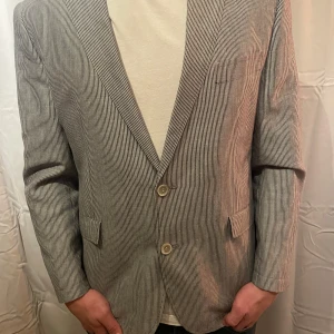 Blå vit randig Kavaj - Säljer en stilren randig kavaj i bomull. Perfekt för både vår och sommar, och funkar lika bra till vardags som till fest. 