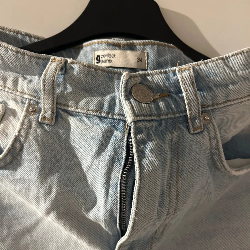 Säljer ett par ljusa jeans från Perfect Jeans i storlek 34. De har en cool, sliten look med hål vid knäna och en klassisk femficksdesign. Perfekta för en avslappnad stil! 🕶️. Jeans & Byxor.