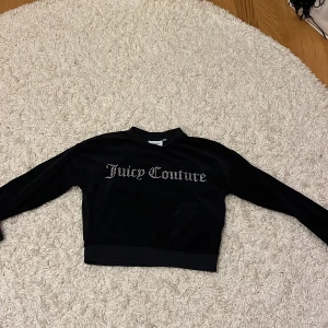 Svart velourtröja från Juicy Couture - Säljer en supermjuk och snygg svart velourtröja från Juicy Couture. Den har långa ärmar och är croppad för en trendig look. Framsidan pryds av Juicy Couture-loggan i glittriga stenar. Perfekt för en avslappnad men stilren outfit! ✨