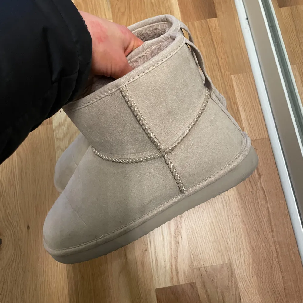 Säljer ett par mysiga beigea boots från H&M. Perfekta för kalla dagar med sin varma insida. De har en enkel design utan snörning och är lätta att ta på. Passar bra till både vardag och avslappnade tillfällen. Använda en gång:). Skor.