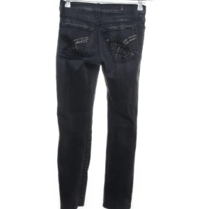 Svarta/ gråa jeans med detaljer  - Snygga svarta/ gråa jeans från 7 For All Mankind med coola detaljer på bakfickorna. Jeansen är i bra skick och har en klassisk design som aldrig går ur stil.