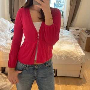 Rosa kofta med knappar - Säljer en söt rosa kofta med knappar framtill. Den har en v-ringad design och långa ärmar💕 Koftan är i bra skick och passar till både jeans och kjol. Perfekt för en casual look eller en dag på stan! 🌸från märket Marks & Spencers