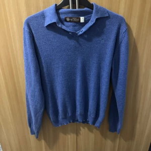 Blå tröja från Morris - Säljer en snygg blå tröja från Morris i 100% extrafin merinoull. Tröjan har en klassisk krage med knappar och långa ärmar. Perfekt för både höst och vinter, och den är i mycket bra skick. Supermjuk och stilren, perfekt för att hålla sig varm och snygg! Skriv via intresse ! Tröjan har krympt från storlek M till S