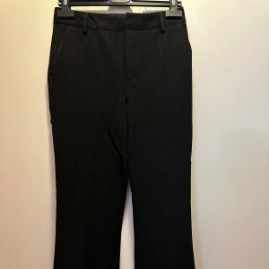 Svarta kostymbyxor med diskreta ränder  - Säljer mina snygga knappt använda kostymbyxor från bikbok med gråa ränder på då jag inte använder dom. Dom är samma modell som bikboks andra perfekta kostymbyxor. Dom är stretchiga och sitter snyggt