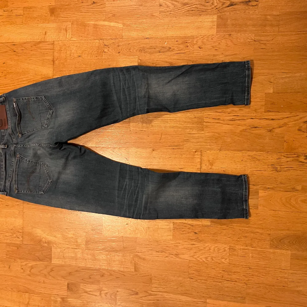 Säljer ett par snygga G-Star RAW 3301 slim jeans i mörkblå denim. De har en klassisk femficksdesign och är i bra skick. Perfekta för både vardag och fest! 🕺. Farkut & Housut.