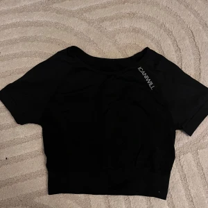 Svart kortärmad träningstop från ICANIWILL - Snygg svart croppad träningstopp från ICANIWILL i ett mjukt och stretchigt material. Perfekt för träning eller en avslappnad dag. Den har en kortärmad design och en bekväm passform. Loggan är tryckt på framsidan. Använt lite🖤
