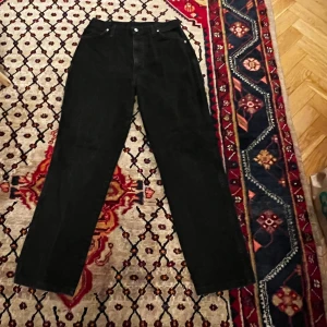 Svarta jeans från Wrangler - Säljer ett par klassiska svarta jeans från Wrangler i storlek 32. De har en straight passform och är tillverkade i 100% bomull. Perfekta för både vardag och fest! 🖤