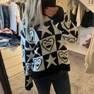 Svartvit stickad tröja med hjärtan och stjärnor - Superfin svartvit stickad tröja med ett coolt mönster av hjärtan och stjärnor. Tröjan är lite oversized och har långa ärmar. Jätte mysig och varm, bra skick!!🖤🤍