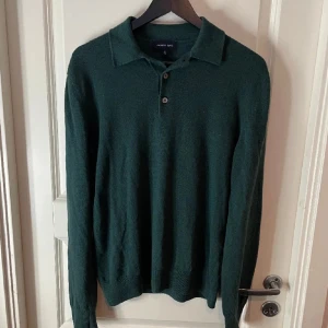 Mörkgrön kashmirtröja från Andrew James - Säljer en elegant mörkgrön kashmirtröja från Andrew James i storlek S. Tröjan har en klassisk pikékrage med tre knappar och långa ärmar. Perfekt för höst och vinter, både stilren och bekväm. Passar lika bra till vardags som till mer uppklädda tillfällen.