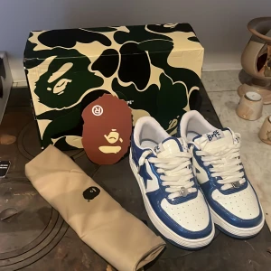 Blå och vita sneakers från BAPE - Säljer ett par snygga BAPE sneakers i blått och vitt. Skorna är använda 1 gång och kommer med skobox+ dustbag. Skriv privat för mer info och bilder.