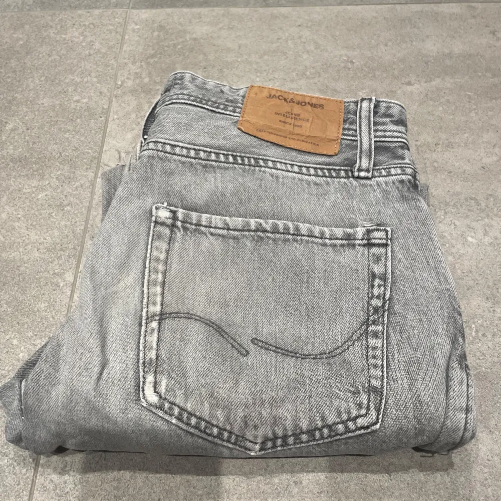 Säljer ett par grå jeans från Jack & Jones i loose fit.Jeansen är i bra skick. Skriv vid funderigar storlek 31/30. Jeans & Byxor.