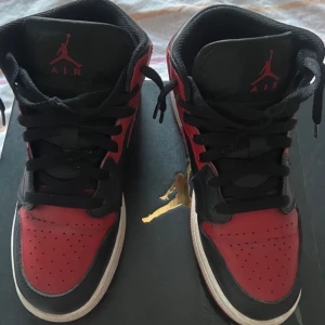 Nike Air Jordans i rött och svart - Säljer ett par klassiska Nike Air Jordans i rött och svart. Skorna har en snygg design med snörning och är i mycket bra skick. Perfekta för både vardag och fest! De har en bekväm passform och är ett måste för alla sneakerheads.