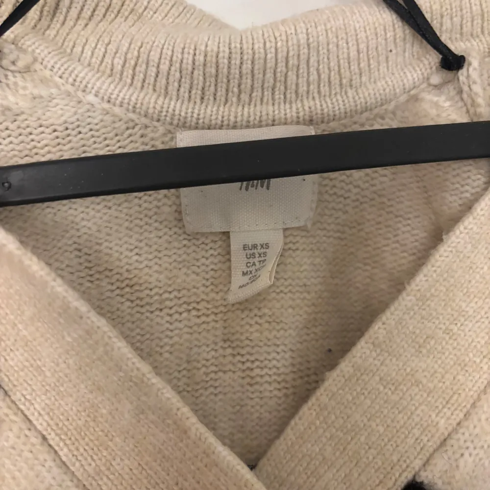 Säljer en supermysig randig tröja från H&M i svart och beige. Den är stickad med en v-ringad design och har långa ärmar. Perfekt för höst och vinter när du vill hålla dig varm och stilren. Passar både till jeans och kjol!. Tröjor & Koftor.