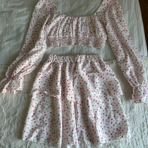 Blommigt set  - Jättegulligt blommigt set med topp och kjol. I mycket bra skick då det lampor har använts!