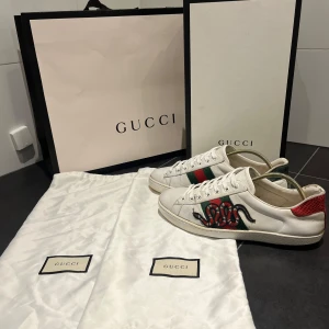 Gucci ace skor  - Säljer nu dessa otroligt feta Gucci ace skorna, helt okej skick finns defekt på sidan av skorna, storlek 7 men passar 8/9 som motsvarar 41/42, endast skorna!! Priset kan diskuteras vid snabb affär 