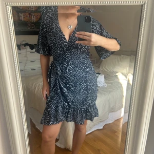 Prickig omlottklänning  - Prickig klänning i ett lätt flowigt material. Underbar att bara slänga på sig när de är riktigt varma dagar. Jätte fint skick🥰❤️