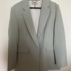 Mintgrön kavaj från H&M - Säljer en stilren mintgrön kavaj från H&M. Perfekt för både vardag och festliga tillfällen. Passar bra till höst och vår! Färgen gör sig inte rätt på bild tyvärr. 