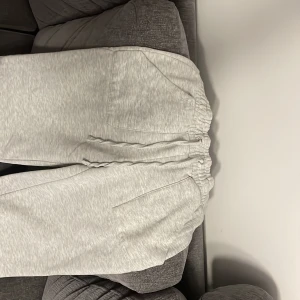 Grå mjukisbyxor - Säljer ett par superbekväma grå mjukisbyxor. Perfekta för chill dagar hemma eller en snabb tur till affären. De har en elastisk midja och praktiska fickor. Materialet är mjukt och skönt, vilket gör dem till ett måste i garderoben!