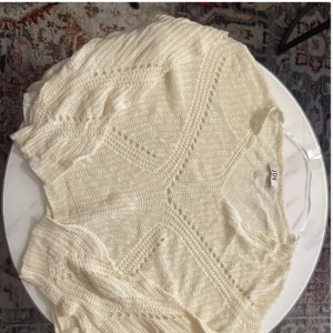 Vit stickad tröja från JDY - Säljer en superfin vit stickad tröja från JDY. Den har ett snyggt mönster med hålstickning och en v-ringad design. Tröjan är långärmad och perfekt för både höst och vinter. Den är i bra skick och passar perfekt till både jeans och kjol. Perfekt för en mysig dag eller en casual utekväll! 💫