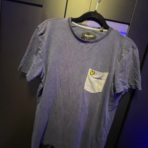 Blå t-shirt från Lyle & Scott - Säljer en blå t-shirt från Lyle & Scott i storlek S. säljer då den bara ligger i garderoben och samlar damm. vid funderingar och frågor så är det bara att höra av sig svarar på allt.