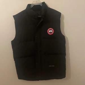 Canada Goose väst - Säljer västen då jag inte använder den längre. Skick 8/10 Kvitto finns. Västen är i Xxl men är liten i storlek så sitter som en xl