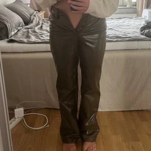 Byxor i olivgrön skinnimitation - Sjukt snygga byxor. Älskar modellen! Helt oanvända - lappen sitter kvar. Säljer pga att de är för små i midjan (så skulle säga att de snarare är en strl 36 midjemässigt). Nypris: 299kr