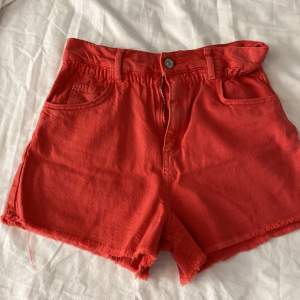 Säljer ett par coola röda shorts från Zara i storlek 152 (11-12 år) De har en hög midja och en snygg fransig kant längst ner. Shortsen är gjorda i ett bekvämt bomullsmaterial och har både fram- och bakfickor samt en dragkedja framtill. Perfekta för sommardagar! 🌞