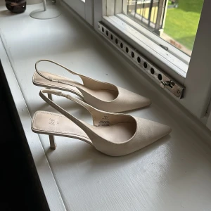 Beige pumps med spetsig tå - Säljer ett par eleganta beige klackar med spetsig tå. Skorna har en smal klack. De är i nyskick och har en stilren design som passar till många olika outfits.