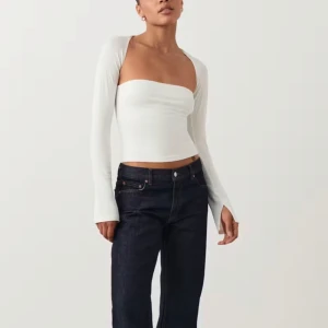 Vit långärmad topp - Snygg vit långärmad topp med en unik design som har en fyrkantig halsringning. Toppen har en tight passform, perfekt för en stilren look.