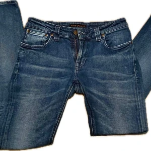Blå nudie jeans - Blåa nudie jeans med bra passform för tjejer. Inte använda mycket alls, snygg wash på dom som gör att dom sticker ut lite mer på outfiten! Strlk W29 L32, cond: 9/10. Hör gärna av er för fler frågor eller fler bilder!