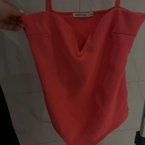 Neon rosa body - Neon rosa body med v-ringing från Nelly. Storlek S. Perfekt för mer festligare tillfällen med neon tema! Knappast använd! Pris går att diskutera 😊