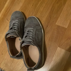 Grå sneakers från Christian Louboutin - Säljer mina Loubs då ja har nya skor är i bra skick är bara smutsiga men går att lösa pris kan diskuteras vid snabb affär storlek 45 men passar 44