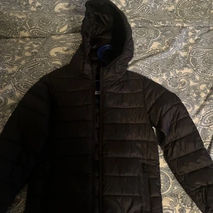 Svart pufferjacka från Jack & Jones - Säljer en svart pufferjacka från Jack & Jones. Jackan har en quiltad design med långärmade ärmar och dragkedja framtill. Perfekt för kyligare dagar med sin stilrena look och varma känsla. 🖤 Jackan är nästan aldrig använd 💕