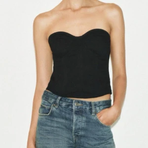 Svart jeans korsett - Snygg svart korsett i jeans. Den är axelbandslös och har en tight passform. Perfekt för en kväll ute eller att styla med jeans för en cool look. Den är från Zara, helt ny, säljer då den ej passade, prislapp kvar⭐️