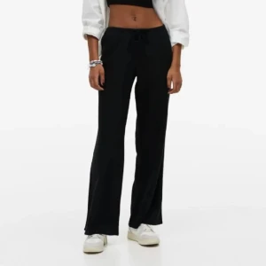 Svarta linnebyxor från H&M - Snygga svarta linnebyxor från H&M med en avslappnad passform. Byxorna har en dragsko i midjan för justerbar passform och är perfekta för en bekväm stil. De är tillverkade i ett lätt och luftigt material.
