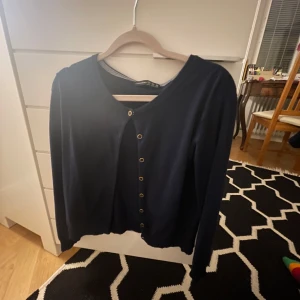 Mörkblå kofta från Atmosphere - Säljer en stilren mörkblå kofta från Atmosphere med knappar framtill. Perfekt för lager-på-lager och passar till många olika outfits. Koftan har långa ärmar och en klassisk design. Skulle säga att den passar xs/s.