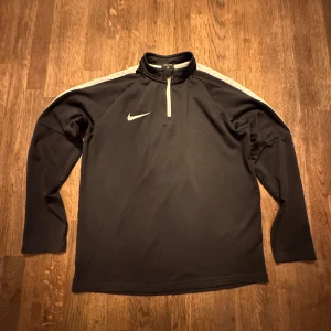 Nike tröja  - Nike tröja svart med 1/4 Zip storlek L barnstorlek (147-158 cm) (12-13 yrs) tröjan är använd men är fortfarande i väldigt bra skick 