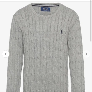 Grå stickad tröja från Polo Ralph Lauren - Ordinarie pris 1300kr, fungerar både för män och kvinnor. Säljer en stilren grå stickad tröja från Polo Ralph Lauren med kabelstickat mönster. Tröjan har en rund halsringning och det klassiska Polo-logotypen broderad på bröstet. Perfekt för kyligare dagar!