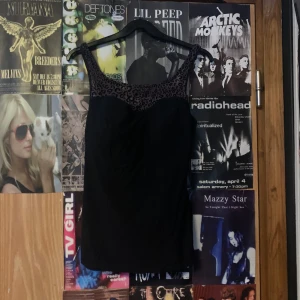 Svart top med leopardmönster - Snygg svart too med leopardmönstrade detaljer vid halsringningen. Perfekt för en kväll ute eller en speciell tillställning. Snygg och går in på en vintage look.