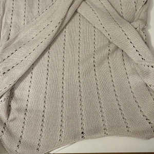 Beige stickad tröja från 157 - Säljer en  beige stickad tröja från 157. Tröjan har ett diskret hålmönster som ger en fin textur. Perfekt för lager-på-lager under kyligare dagar. Passar till både jeans och kjol för en avslappnad look. 