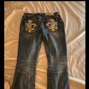 Blå jeans med broderade bakfickor - Säljer mina miss me jeans i storlek 26w!❤️ ytterbenslängd: 101 cm innerbenslängd: 76 cm, Midja: 37cm, Benöppning: 24 cm! Skriv innan du köper och ställ frågor vid funderingar!❤️ har lite slitningar längst ner utav benen men inte tydligt eftersom modellen är lite hålig! Pris kan diskuteras❤️