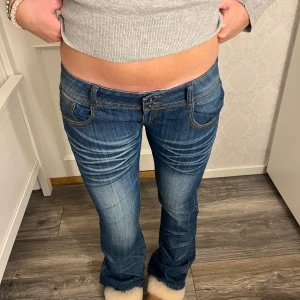 Lågmidjade utsvängda jeans  - Jätte fina jeans från Redseventy! De har en väldigt låg midja med två knappar! Det står storlek L men modellen brukar vanligtvis ha S-M i byxor! Måtten - innerben: 82 cm, midja rakt över: 43 cm❤️ Kom privat för frågor!