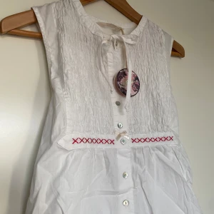 Topp från Odd Molly - Jättefin topp från Odd Molly, helt ny med prislapp. Broderi, rosett, knytning bak och andra fina detaljer som syns på bilderna. 