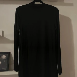 Klänning med halvpolo  - Säljer en stilren svart långärmad klänning med halvpolo från Gina Tricot. 