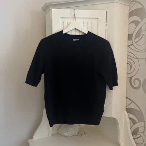 Svart kashmirtröja från H&M - Säljer en stilren svart kashmirtröja från H&M. Tröjan har korta ärmar och en klassisk rund halsringning. Perfekt för en elegant och bekväm look. Passar bra till både jeans och kjol.