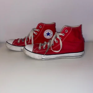 Röda Converse All Star sneakers - Klassiska röda Converse All Star sneakers i unisexmodell med vita snören och gummisula. Skorna har den ikoniska logotypen på sidan och är tillverkade i textilmaterial. De är i strl M💞
