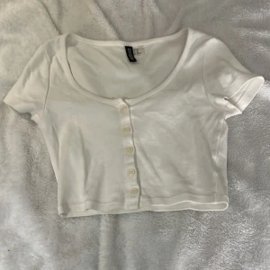 Vit croppad topp från H&M - Säljer en vit croppad topp från H&M:s kollektion DIVIDED. Nästan oanvänd. Storlek XS. 