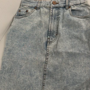 Ljusblå jeanskjol - Trendig ljusblå jeanskjol med figurnära look, även stretchig i materialet. Perfekt för en avslappnad stil. Aldrig använd