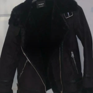 Svart skinnjacka från Pull&Bear - Säljer en snygg svart skinnjacka från Pull&Bear. Den har en fluffig krage och dragkedjor på sidorna. Perfekt för höst och vinter, och den ger en cool look med sina detaljer. Passar bra till både vardag och fest!