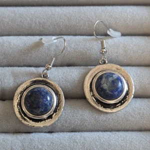 Silverfärgade örhängen med blå sten - Snygga silverfärgade örhängen med en rund blå sten i mitten..De har en klassisk krok för enkel användning.använd endast en gång 